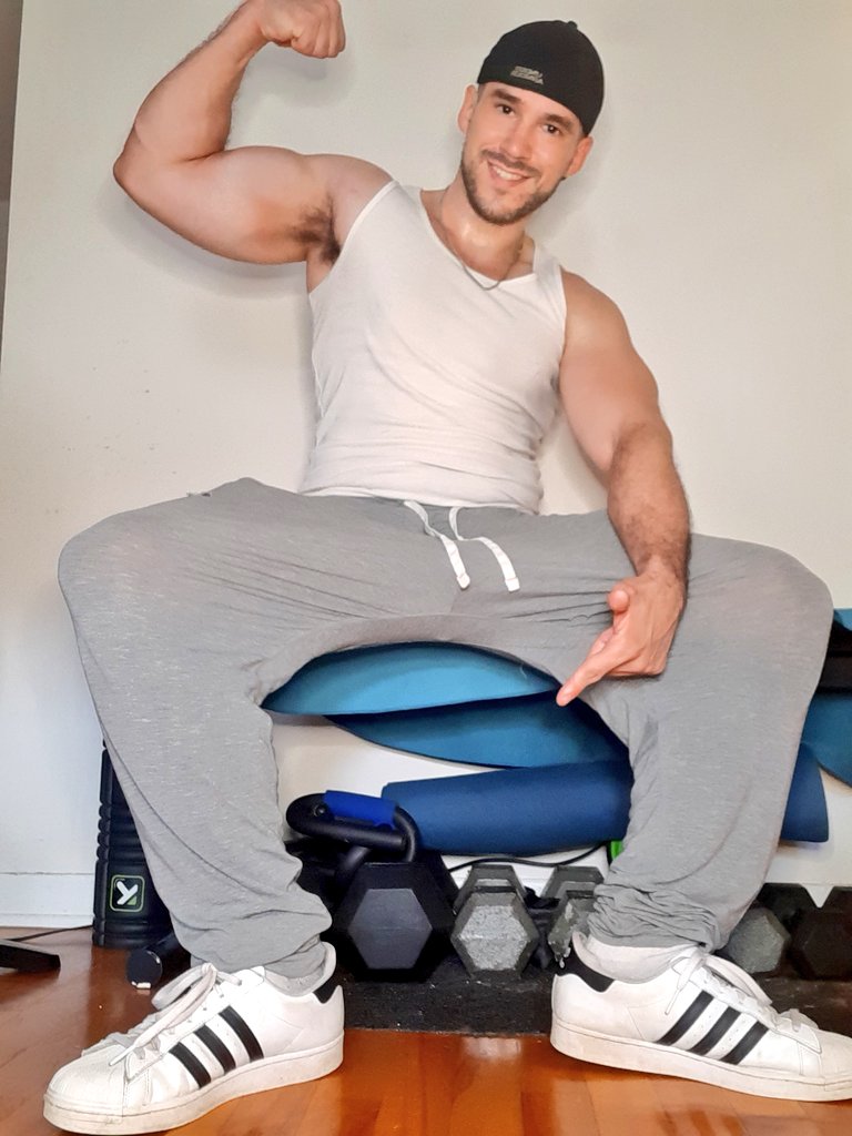 Cole Colossus (@colecolossus) modello gay tiktok onlyfans seduto che flette i muscoli del braccio