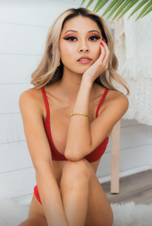 Jamie Luna ou @jamieluma, un modèle asiatique Onlyfans en forme posant pour une photo portant une paire de bikinis rouges.